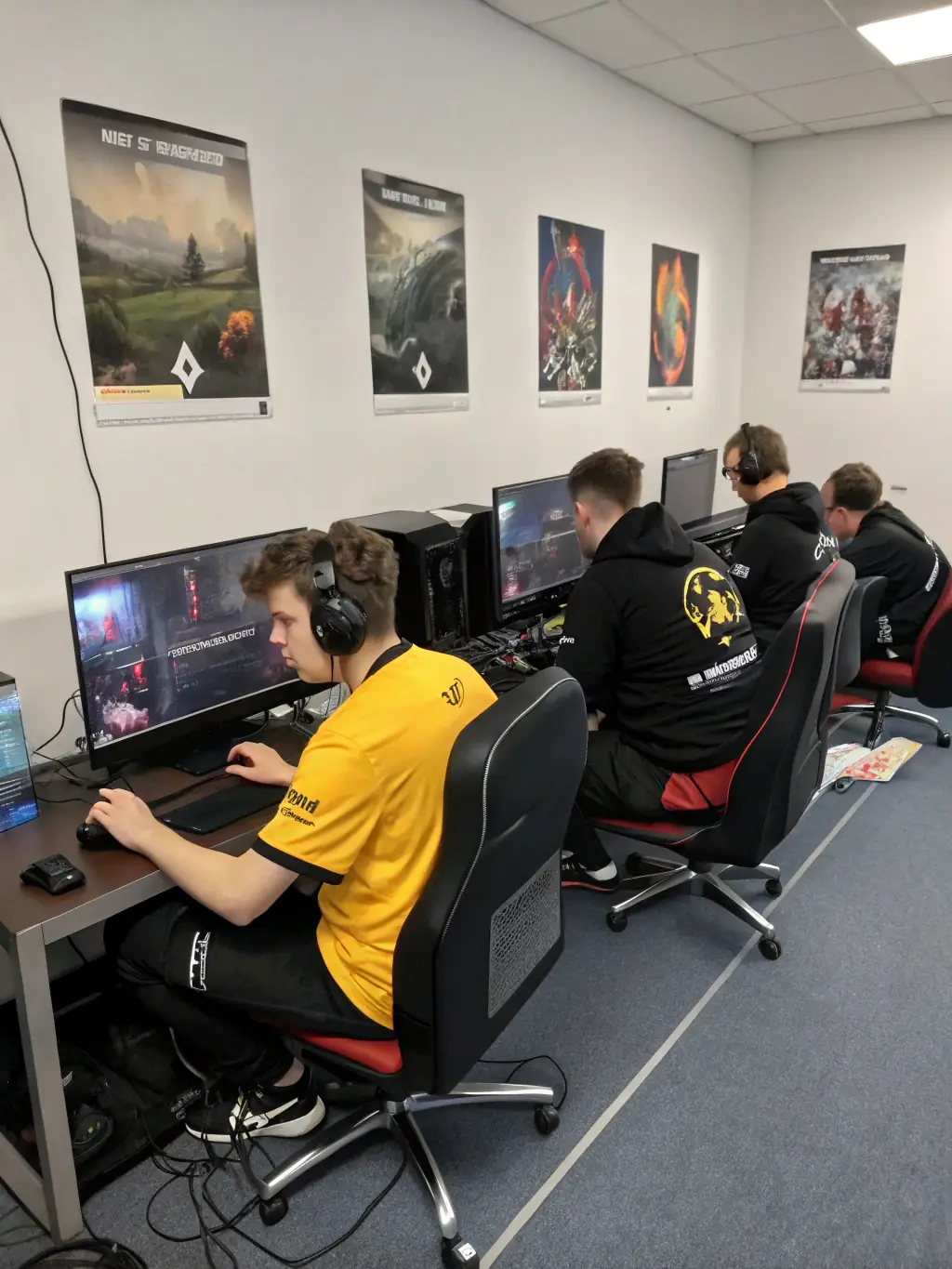 A group of young adults participating in an OCV PLAY-organized gaming tournament, showcasing teamwork and friendly competition in a brightly lit esports arena.